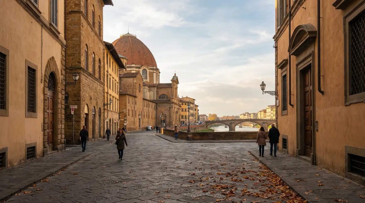 Lungarno a Firenze con passanti, cupola del Duomo sullo sfondo e ponte sul fiume in una giornata tranquilla